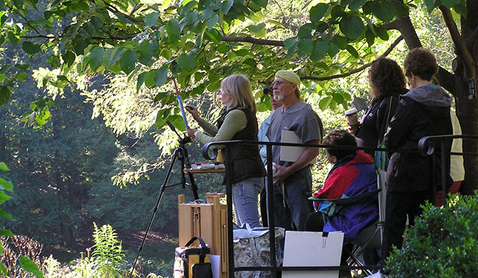 A group of adults participating in a landscape painting class at Reeves-Reed Arboretum