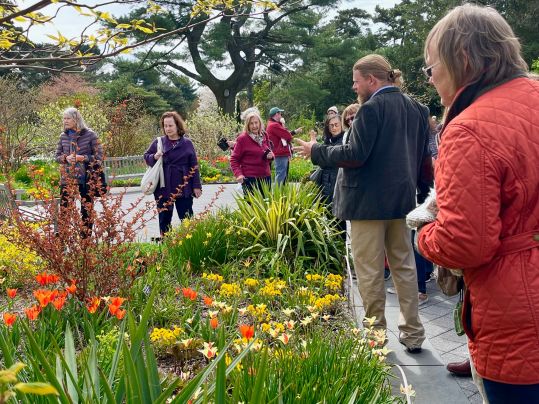 Tour group walking through flower gardens during a trip