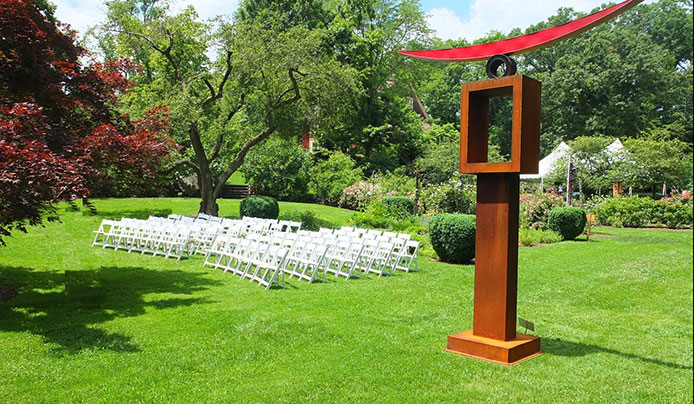 Outdoor seating for a wedding on the great lawn with a wooden statue