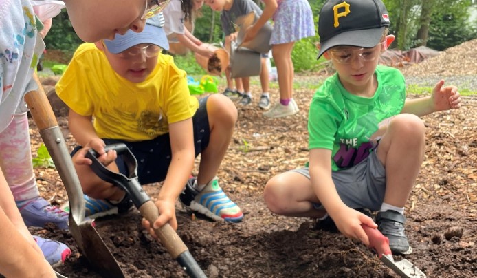 Kids shoveling and planting in the dirt