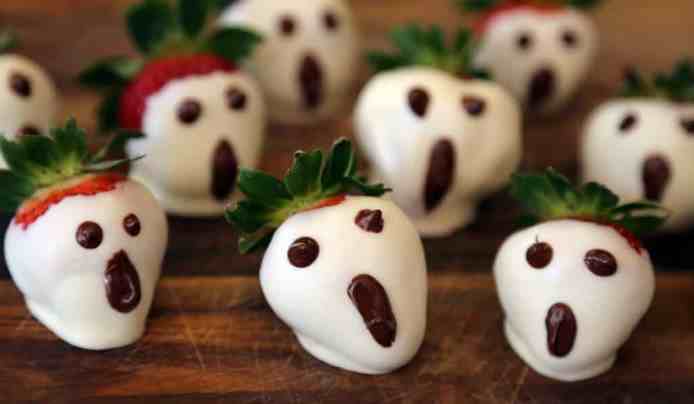 Strawberries decorated like spooky ghosts